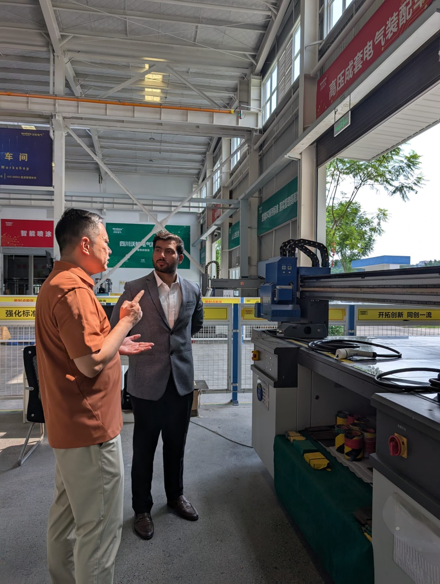 Charginity team member in discussion with a manufacturing partner inside an assembly workshop in Asia